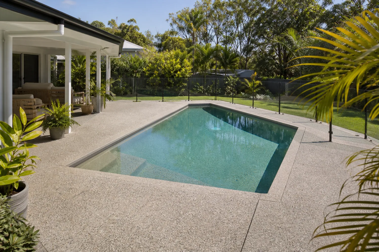 Project inspiration showing an exposed aggregate concrete pool surround